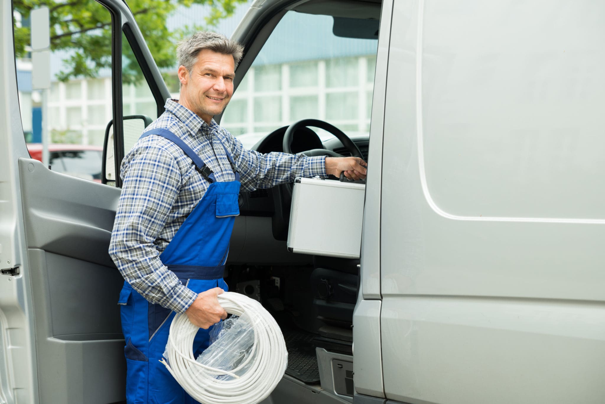 Worker With Toolbox And Cable Entering In Van