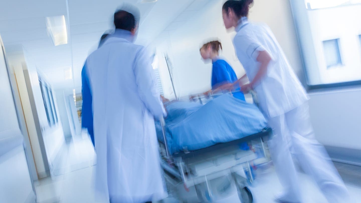 Healthcare team transports patient to procedure room
