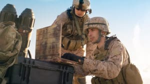 Defense field team communication - Soldiers using laptop in desert operation