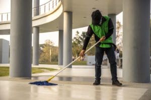Corporate janitor cleaning concrete for large office building - Orion Facilities Management